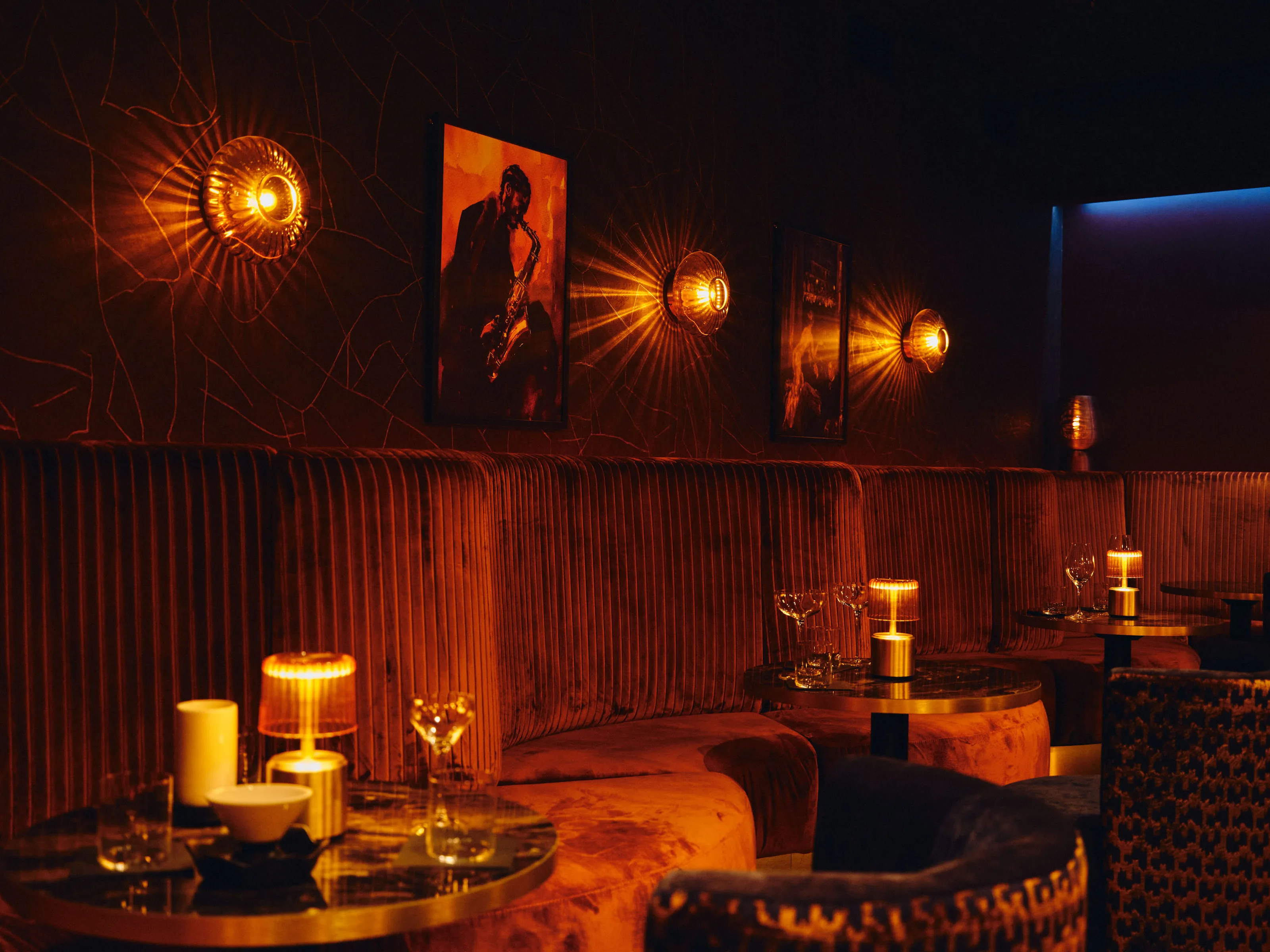 Warmly lit bar interior with golden lighting and a jazz photo on the wall